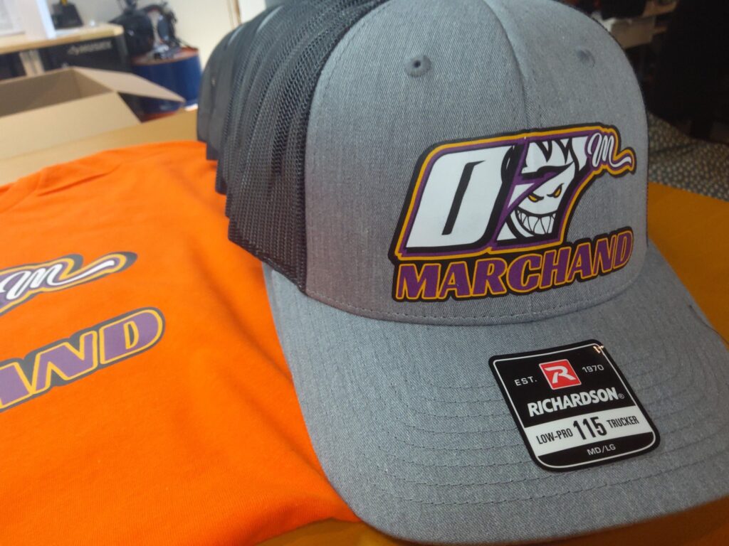 Personnalisation de t-shirts et casquettes pour l'équipe de course Marchand.
